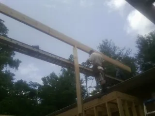 Carpenter setting a ridge beam over a new addition frame — Ice Dam Removal by Roofing Brothers in Lake Huntington