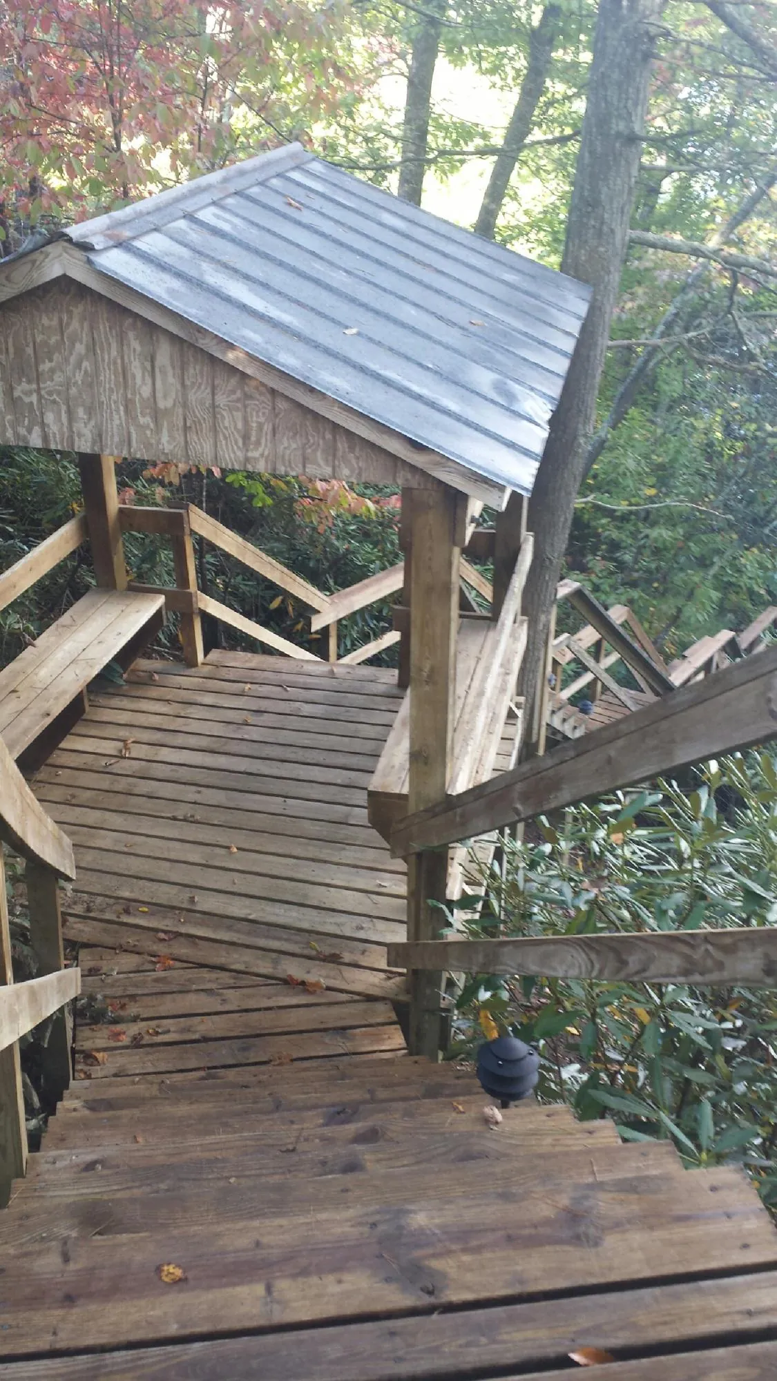 Metal roofed shelter over wooden steps on a wooded walkway — Skylight Repair & Installation work by our crew in Lake Huntington