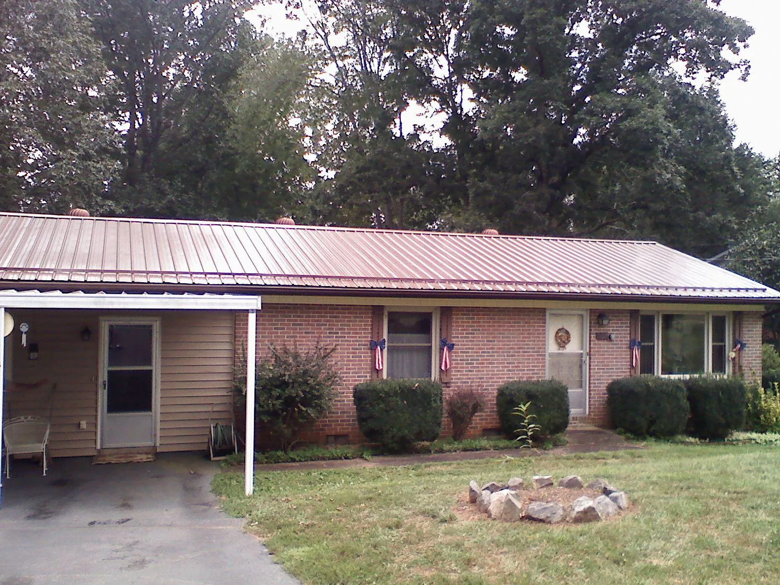Bronze metal roof and carport on a brick ranch home — Roof Repair work by our crew in Lake Huntington